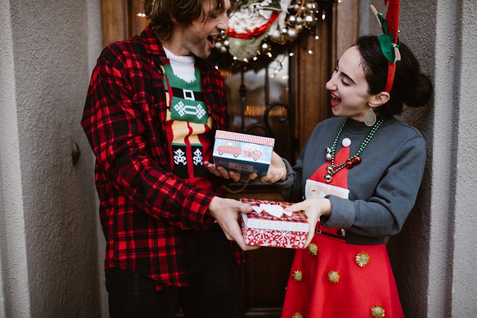 Festive couple exchanging gifts in holiday attire outside a decorated entrance.