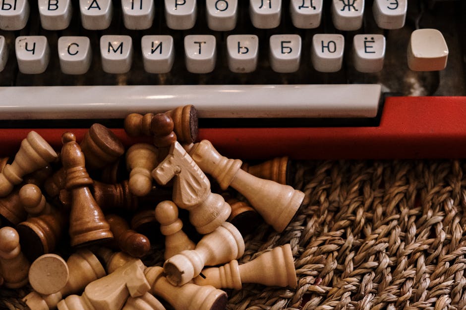 Vintage typewriter paired with scattered chess pieces on woven surface