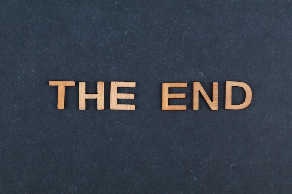 The image displays the phrase 'The End' spelled out in wooden letters against a dark background.