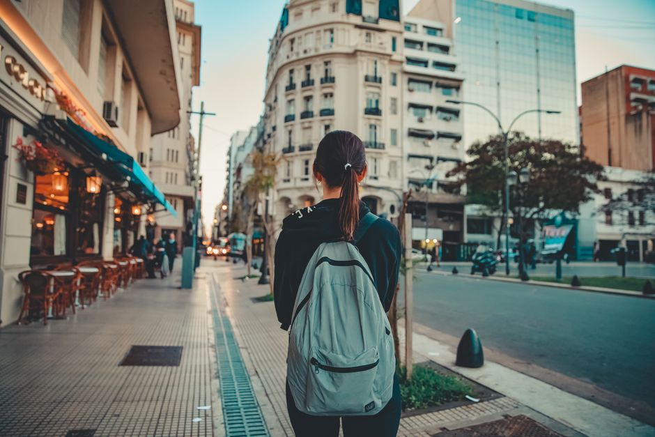 A woman with a backpack walking down a vibrant street in San Nicolás, Buenos Aires, Argentina.