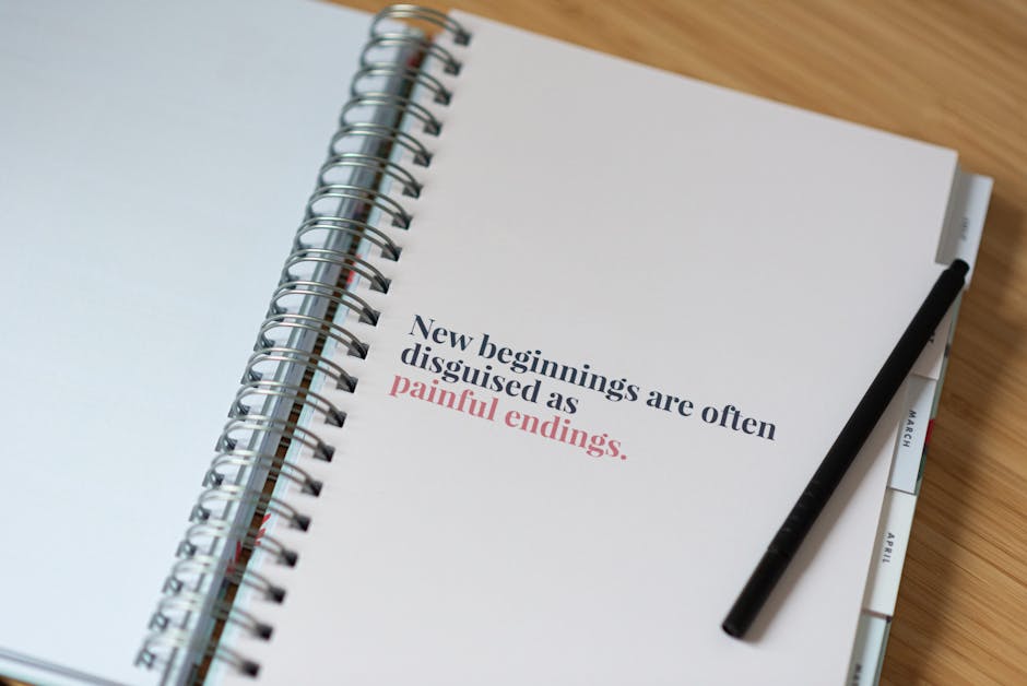 From above of spring notebook with printed text on white paper sheet with pen on desk