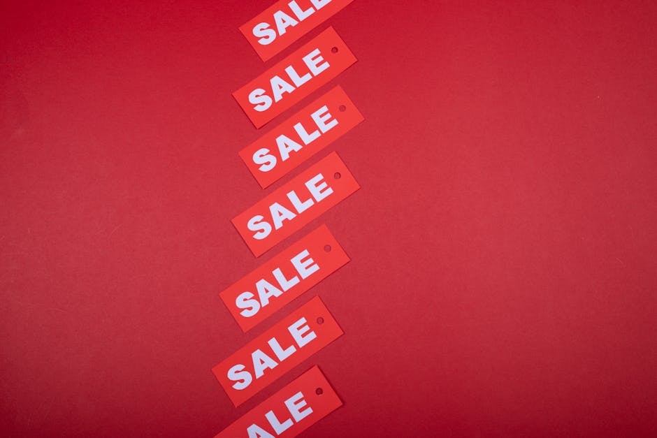Red sale tags aligned diagonally on a red background, perfect for retail promotions.