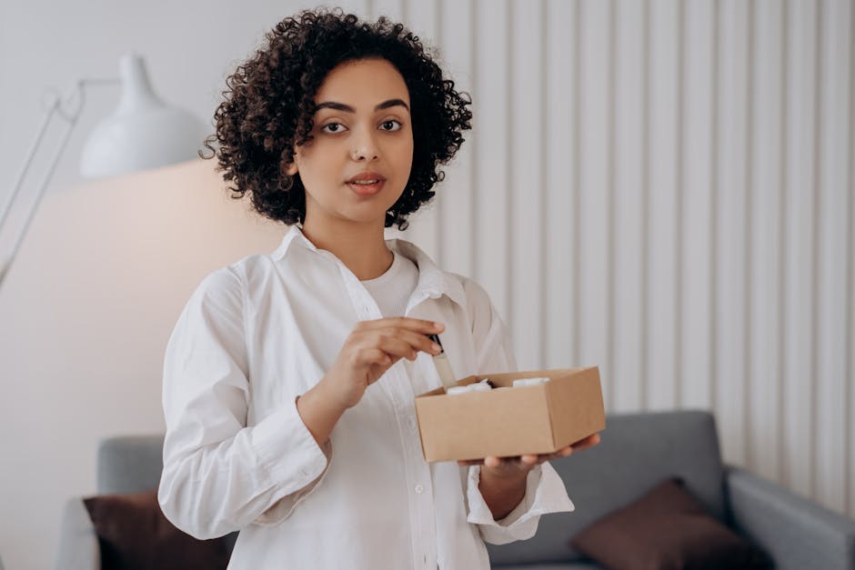 A woman with curly hair holds a box of essential oils, perfect for aromatherapy and relaxation.