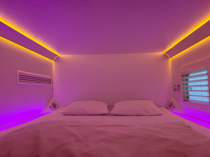 Cozy capsule hotel room with vibrant ambient lighting and minimalistic design.