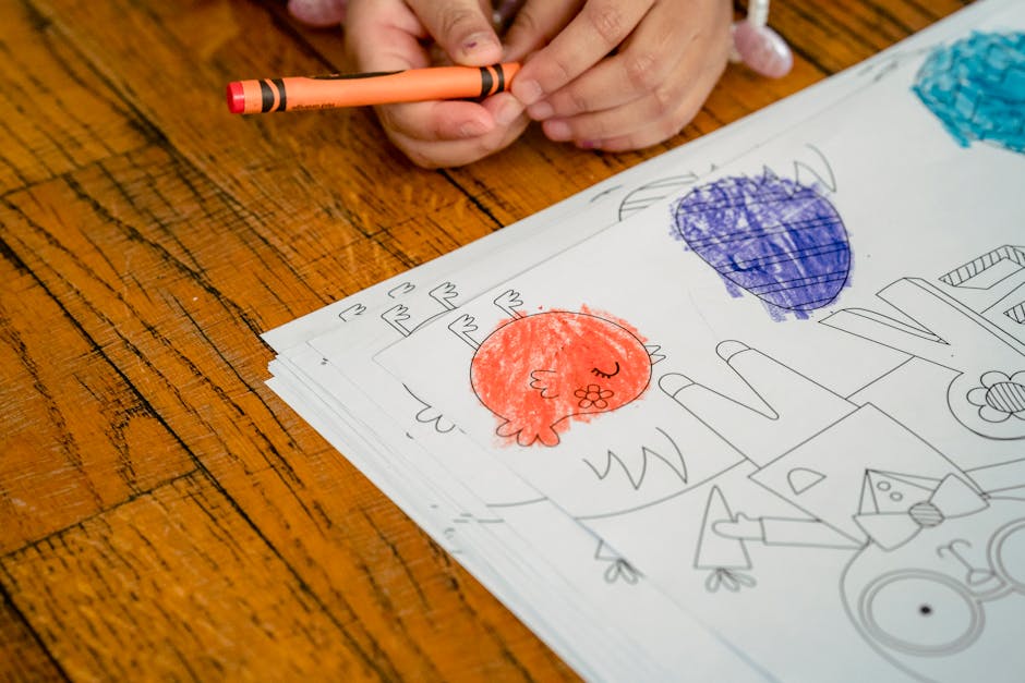 High angle of crop anonymous child at wooden table with painted chicken and eggs on paper for Easter holiday