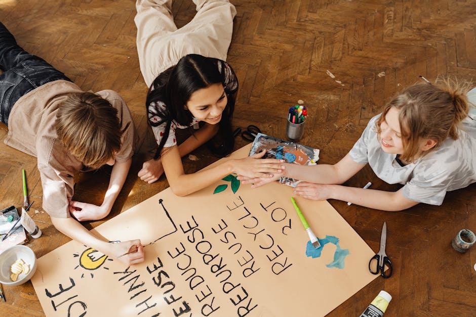 Three teenagers collaborate on an eco-friendly poster, promoting sustainability with creativity indoors.