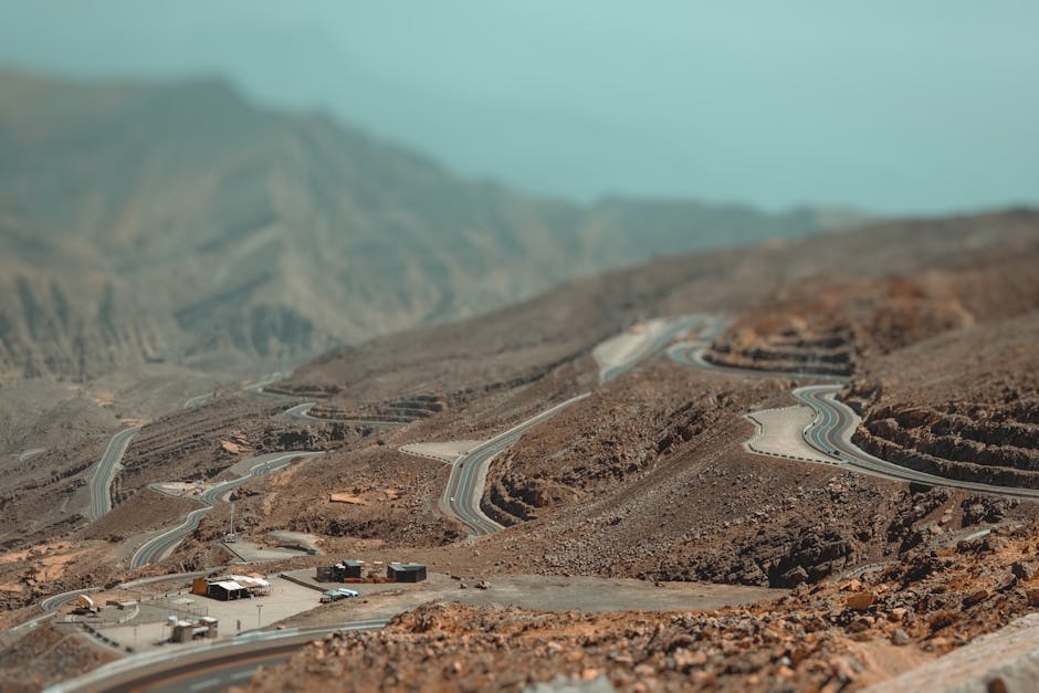 Aerial view of winding roads through the rocky landscape of Jebel Jais in Ras Al-Khaimah, UAE.