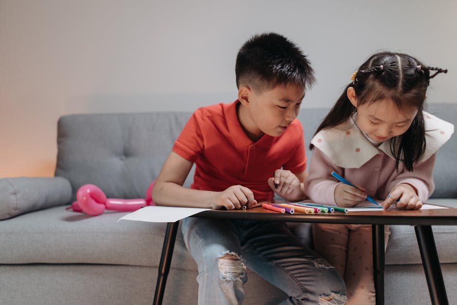 Two children enjoy drawing together on a table indoors, fostering creativity.