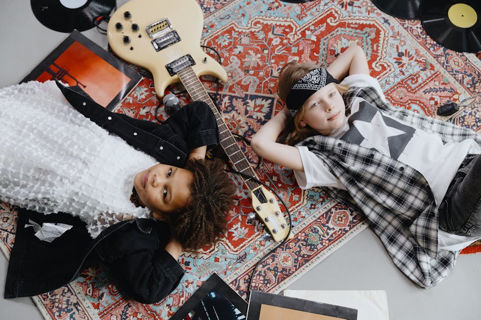 Two stylish children lying on a rug with a guitar and vinyl records, embracing a retro vibe.