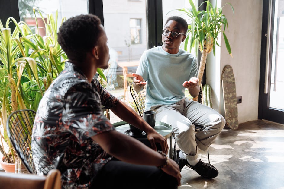 Two friends chatting casually over coffee in a bright indoor cafe.