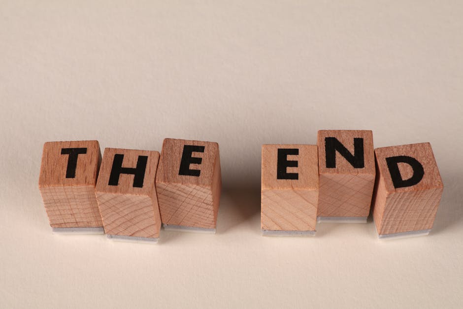Wooden blocks arranged to spell 'The End' on a simple beige background, symbolizing closure.